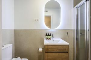 W łazience znajduje się umywalka i lustro. w obiekcie Encantador apartamento Plaza del Callao w Madrycie