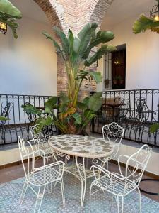 einen Tisch und Stühle sowie eine Pflanze auf dem Balkon in der Unterkunft Hotel 3* La Casona de las Flores in Ondara