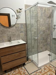 bagno con doccia, lavandino e specchio di Hotel 3* La Casona de las Flores a Ondara
