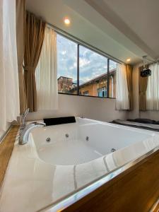 La salle de bains est pourvue d'une grande baignoire et d'une grande fenêtre. dans l'établissement Zeus Living - City Central, à Hô-Chi-Minh-Ville