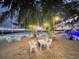 a group of tables and chairs on the beach at night at I Talay Lodge Botique hotel in Rayong