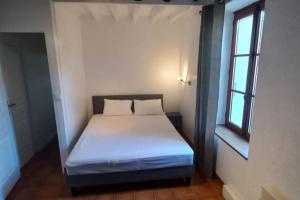 1 dormitorio con 1 cama blanca y ventana en Escapade Rurale: Maison 10 pers, jardin, feu cheminée, en Coulonges