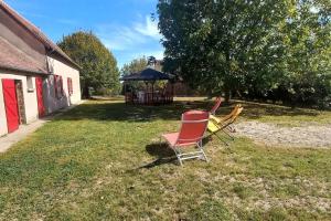 2 sillas sentadas en un patio con cenador en Escapade Rurale: Maison 10 pers, jardin, feu cheminée, en Coulonges