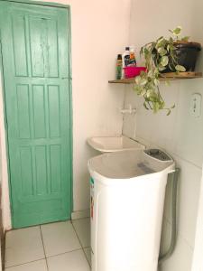 a green door in a bathroom with a trash can at Apto 1030 in Trancoso