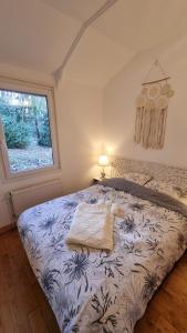 - une chambre avec un lit et une couette bleue et blanche dans l'établissement L'orée du bois, à Hennebont