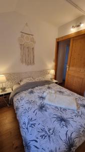- un lit avec une couette bleue et blanche dans une chambre dans l'établissement L'orée du bois, à Hennebont