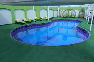 a large swimming pool with chairs in a building at Ramada by Wyndham Multan in Multan