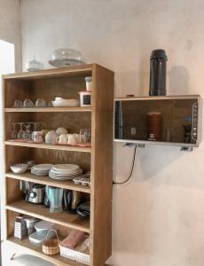 a kitchen shelf with dishes and a microwave at Apto 1030 in Trancoso