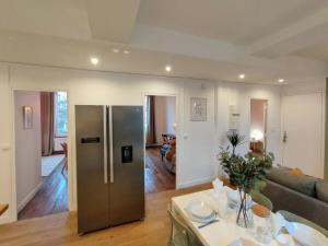 una cucina e un soggiorno con frigorifero in acciaio inossidabile di L’Atmosphère | Centre-Ville Netflix | Mon Groom a Troyes
