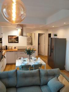 een woonkamer met een bank en een tafel en een keuken bij L’Atmosphère | Centre-Ville Netflix | Mon Groom in Troyes