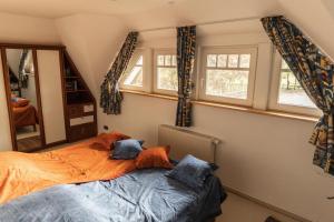 1 dormitorio con 1 cama y 2 ventanas en Ferienhaus LANDHAUS STUHRBERG en Brake