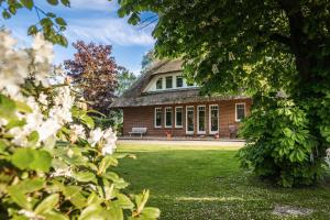 ein Backsteingebäude mit einer Bank im Hof in der Unterkunft Ferienhaus LANDHAUS STUHRBERG in Brake