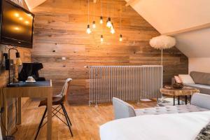 a living room with wooden walls and a table and a couch at Les Jardins d'Epicure in Bray-et-Lû