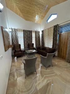 sala de estar con sofá, sillas y mesa en Idyllic Private Cottage w/King Bed + Mountain view en Kasauli