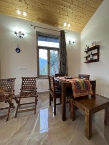 uma sala de jantar com uma mesa e cadeiras e uma janela em Idyllic Private Cottage w/King Bed + Mountain view em Kasauli