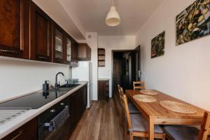a kitchen with a wooden table and a dining room at 2-bedroom Apartment with garage in the city center in Krakow