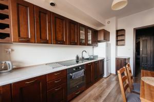 a kitchen with wooden cabinets and a sink at 2-bedroom Apartment with garage in the city center in Krakow