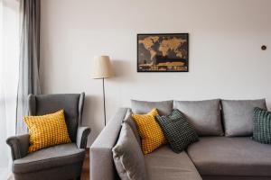 a living room with a gray couch and yellow pillows at 2-bedroom Apartment with garage in the city center in Krakow