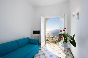 Sofá azul en la sala de estar con vistas al océano en Il Barilotto, en Positano