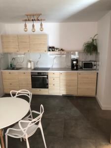 a kitchen with wooden cabinets and a table and chairs at Apartamenty MAJA Nowy Targ in Nowy Targ