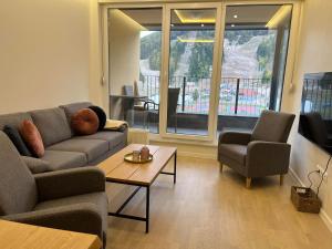 a living room with a couch and a table at Apartman Lido in Bjelašnica