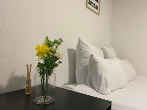 un vase avec des fleurs sur une table à côté d'un canapé dans l'établissement Peaceful Suburban Utopia, à Sandton