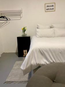 1 dormitorio con 1 cama y un jarrón de flores en Peaceful Suburban Utopia en Sandton