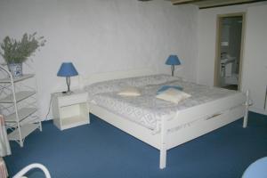 1 dormitorio con 1 cama blanca y 2 lámparas. en Hotel zum alten Schweizer, en Twann