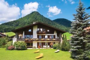 a large house with a mountain in the background at Ferienwohnungen Helga Mayer inkl. Chiemgaukarte in Ruhpolding