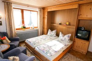 a small room with a bed and a tv at Ferienwohnungen Helga Mayer inkl. Chiemgaukarte in Ruhpolding
