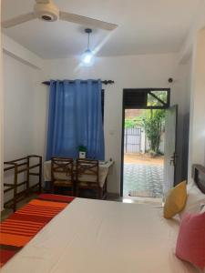 a bedroom with a large white bed and a table at Sri Mali in Matara