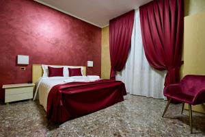 1 dormitorio con cama y pared roja en HOTEL PARADISO, en Altedo