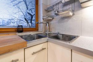 eine Küche mit einem Waschbecken und einem Fenster in der Unterkunft Spora Chata in Nowy Targ