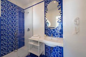 a blue and white bathroom with a sink and a shower at Il Barilotto in Positano