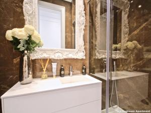 W łazience znajduje się biała umywalka i lustro. w obiekcie Akicity Amoreiras Light w Lizbonie