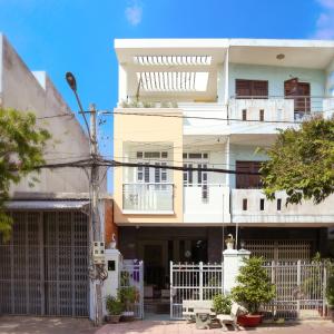 a tall white building with a white fence in front of it at Vit-xiem Room - Double room - Duck Homestay Ben Tre in Ấp Phú Lợi