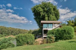 a house on a hill with a tree at The Namkhan in Luang Prabang