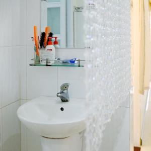 Baño blanco con lavabo y espejo en Vit-xiem Room - Double room - Duck Homestay Ben Tre, en Ấp Phú Lợi