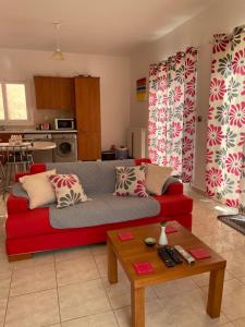 ein Wohnzimmer mit einem roten Sofa und einem Tisch in der Unterkunft Villa Midas in Zóla