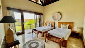 a bedroom with two beds and a balcony at Jabunami Villa in Canggu