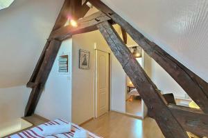 um quarto no sótão com um feixe de madeira num quarto em Travel - Near fairs and city center - Mon Groom em Troyes