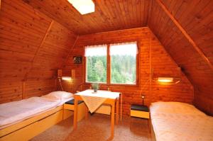 a room with two beds and a table in a cabin at Chata Repiská in Demanovska Dolina