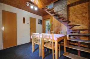 a dining room with a table and chairs and a staircase at Chata Repiská in Belá