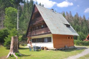 a large wooden house with a gambrel roof at Chata Repiská in Demanovska Dolina +2 photos