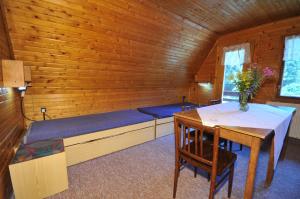 - une chambre avec un lit et une table dans une cabine dans l'établissement Chata Repiská, à Demänovská Dolina