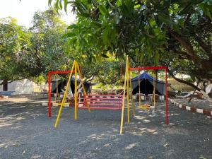 a playground with colorful equipment in a park at Greenlife farm resort in Sasan Gir