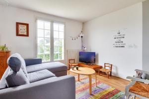 a living room with a couch and a tv at Entre plage et marais salants, maison pour 6 in Les Bussolleries