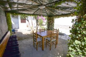 einen Holztisch und Stühle unter einem Sonnenschirm in der Unterkunft Villa Leo in Portoferraio