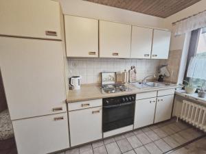 a kitchen with white cabinets and a sink at Appartement Kanew in Petersdorf auf Fehmarn