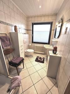 Petersdorf auf FehmarnにあるAppartement Kanewのバスルーム(洗面台、トイレ付)、窓が備わります。